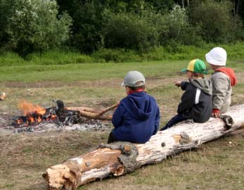 Boys Staying Warm at a Campfire